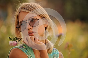 Beautiful young girl watering flowers on the flowerbed. The concept of a good housewife in her house