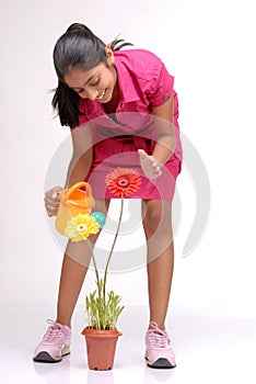 Beautiful young girl watering a plant