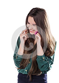 Beautiful young girl on a white background is a pink cell phone telefonom.Govorit. Smiles. Surprised.