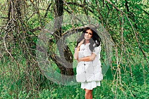 Beautiful young girl in white dress in spring blossoming apple orchards