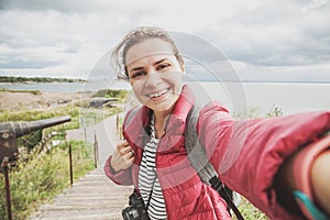 Beautiful young girl woman traveler makes selfie on an island Suomenlinna, sveaborg, Finland