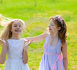 Young girls with blue eyes in white dresses in garden with apple trees blosoming