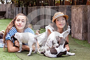 Beautiful young girls having fun with their small French Braque puppies