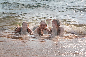 Waves Splash Girls Laying on the Sand