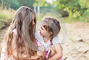 Beautiful young girls with long hair; smiling and talking at sum