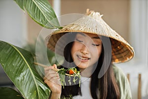 Beautiful young and happy asian woman eating healthy salad with fresh organic vegetables