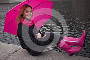 Beautiful young and happy blond woman with colorful umbrella on the street. The concept of positivity and optimism