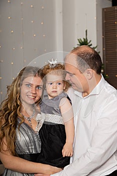 Beautiful young happy family with a child in her arms on New Year`s Eve. New Year 2020.