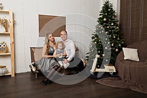 Beautiful young happy family with a child on New Year`s Eve on the couch. New Year 2020.