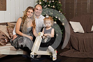 Beautiful young happy family with a child on New Year`s Eve on the couch. New Year 2020.