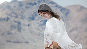 Beautiful young happy free local woman looking back at camera smiling and flirting at sunny salt desert lake in Utah.