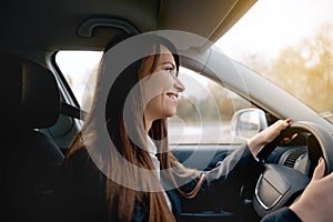 Beautiful young happy smiling woman driving her new car.