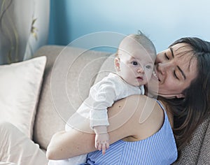 Beautiful happy young brunette woman with newborn baby on her hands, family happiness, love and care concept, mother day