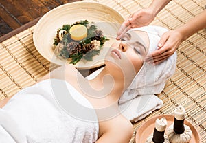 Beautiful, young and healthy woman on bamboo mat in spa salon ha