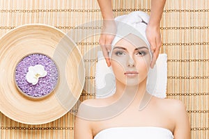 Beautiful, young and healthy woman on bamboo mat in spa salon ha