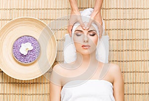 Beautiful, young and healthy woman on bamboo mat in spa salon ha