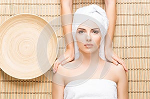 Beautiful, young and healthy woman on bamboo mat in spa salon ha