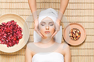 Beautiful, young and healthy woman on bamboo mat in spa salon ha