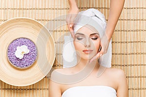 Beautiful, young and healthy woman on bamboo mat in spa salon ha