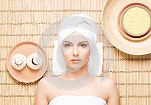 Beautiful, young and healthy woman in spa salon on bamboo mat. S