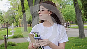 Beautiful young high school girl messaging on smartphone surfing internet.