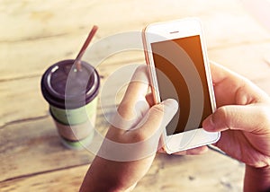 Beautiful young hipster woman using smart phone in coffee shop, female watching her cell telephone while relaxing in cafe