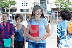 Beautiful young hispanic female student with group of young adults