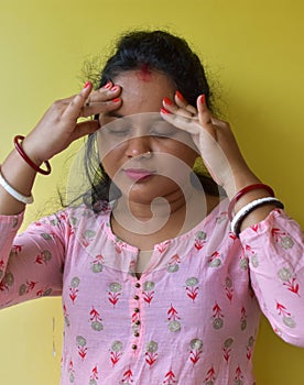 Beautiful young Indian woman holding head in pain. Headache, sick, flue concept