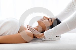 Beautiful young indian woman receiving relaxing shoulder massage