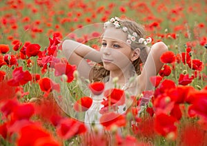 Beautiful young kid in red poppy field