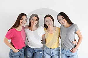 Beautiful young ladies in jeans and colorful t-shirts on background. Woman`s Day