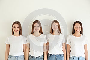 Beautiful young ladies in jeans and white t-shirts on background. Woman`s Day