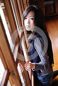 Beautiful young lady behind the wooden door