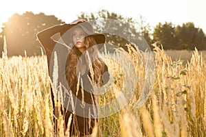 Beautiful young lady in a brown dress in a field - sunrise shot