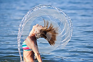 Beautiful young lady splashing with her hair