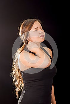 Beautiful young lady Suffer crick after workout in a black background