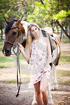 Beautiful young lady wearing vintage dress riding a horse at sun