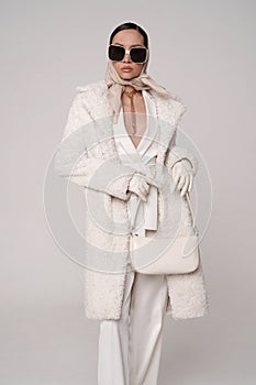 Beautiful young lady in a white faux fur coat