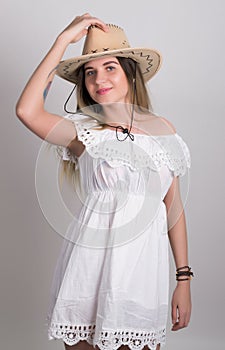 Beautiful young leggy blond Country girl in a litl white dress and cowboy hat with a guitar