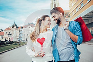 Beautiful young lovers holding a big red heart