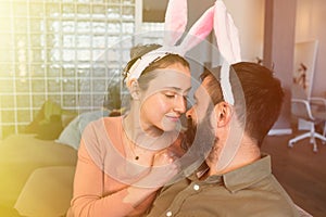 Beautiful young loving couple bonding to each other and smiling while woman holding a book. Having fun time at home.