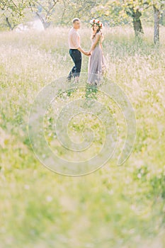 Beautiful young loving couple embracing in blossom spring garden. Romantic dating