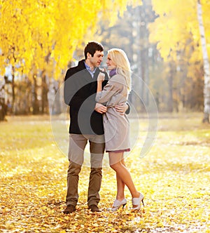 Beautiful young loving couple hugging in sunny autumn