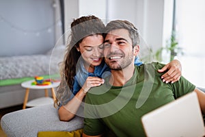 Beautiful young loving couple relaxing while woman embracing her boyfriend and smiling
