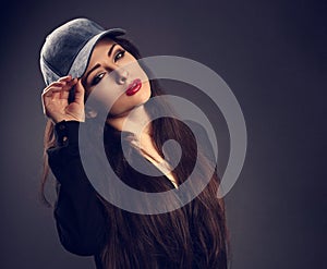 Beautiful young make-up model in blue baseball cap with red