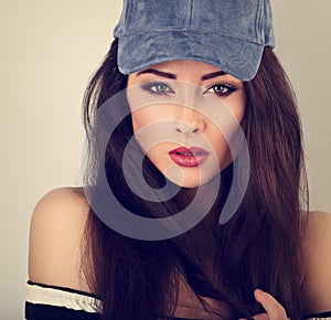 Beautiful young make-up model posing in blue baseball cap w