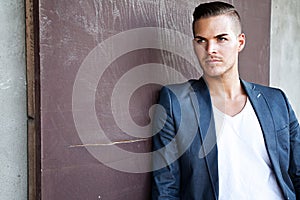 Beautiful young man outdoors against a wall