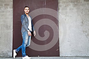 Beautiful young man outdoors against a wall