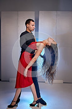 Beautiful young man and woman in suits preparing for performance on stage, rehearsal