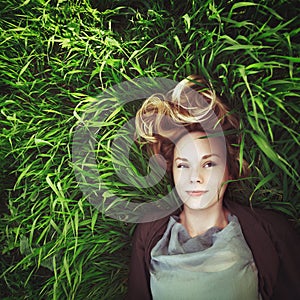 Beautiful young meditative woman in the grass. Instagram effect. photo
